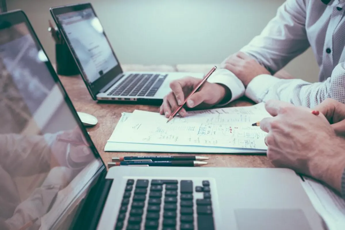 Property manager planning a website budget at a desk with a laptop